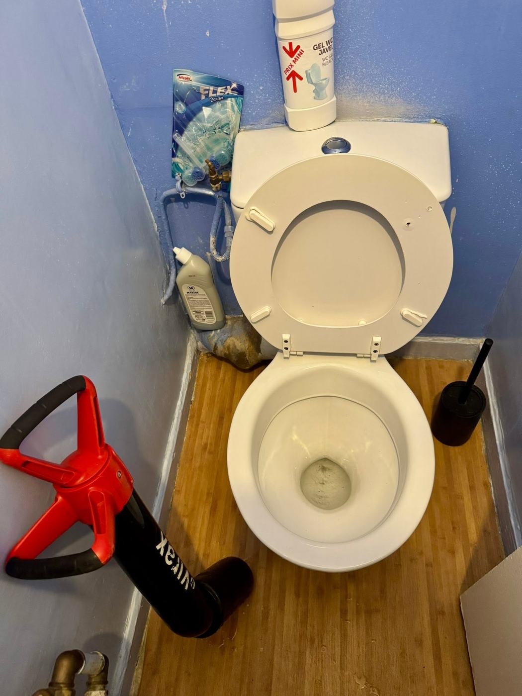 Déboucheur en place au pied d'une cuvette de WC
