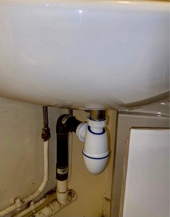 Siphon neuf posé sous le lavabo