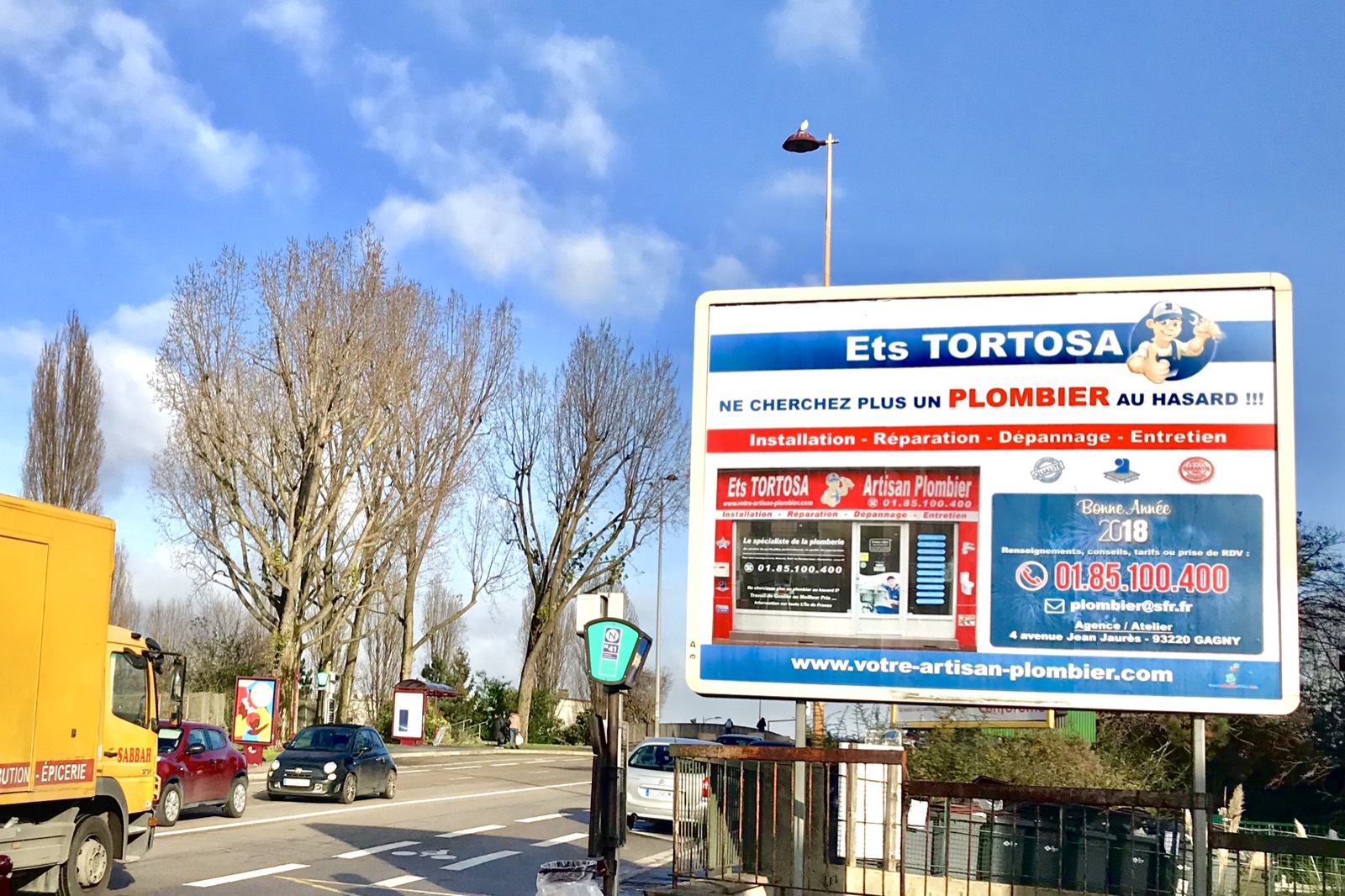 Panneau publicitaire des Ets TORTOSA le long d'un axe routier à Gagny